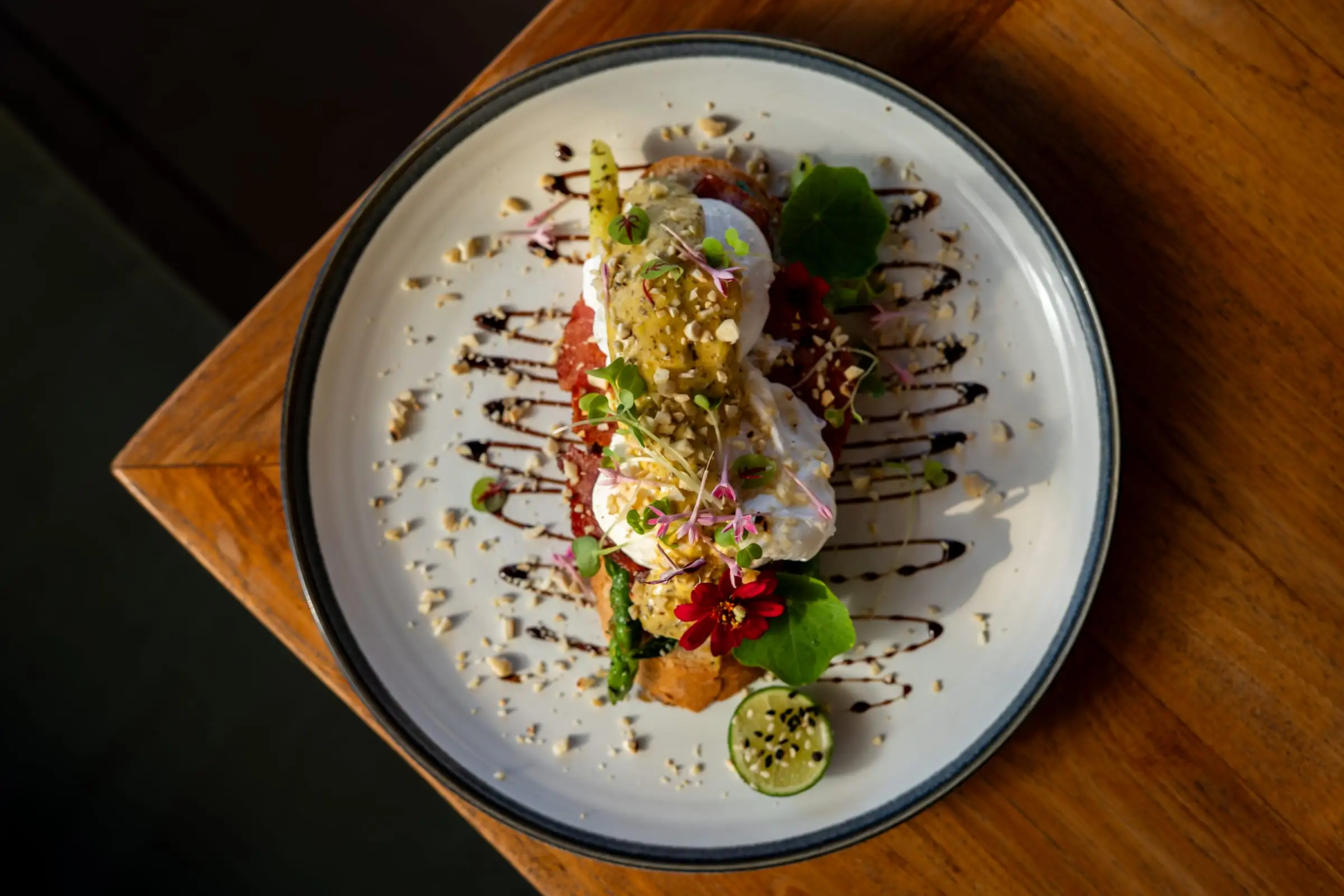 Flower-garnished brunch dish on a wooden table, shot from above