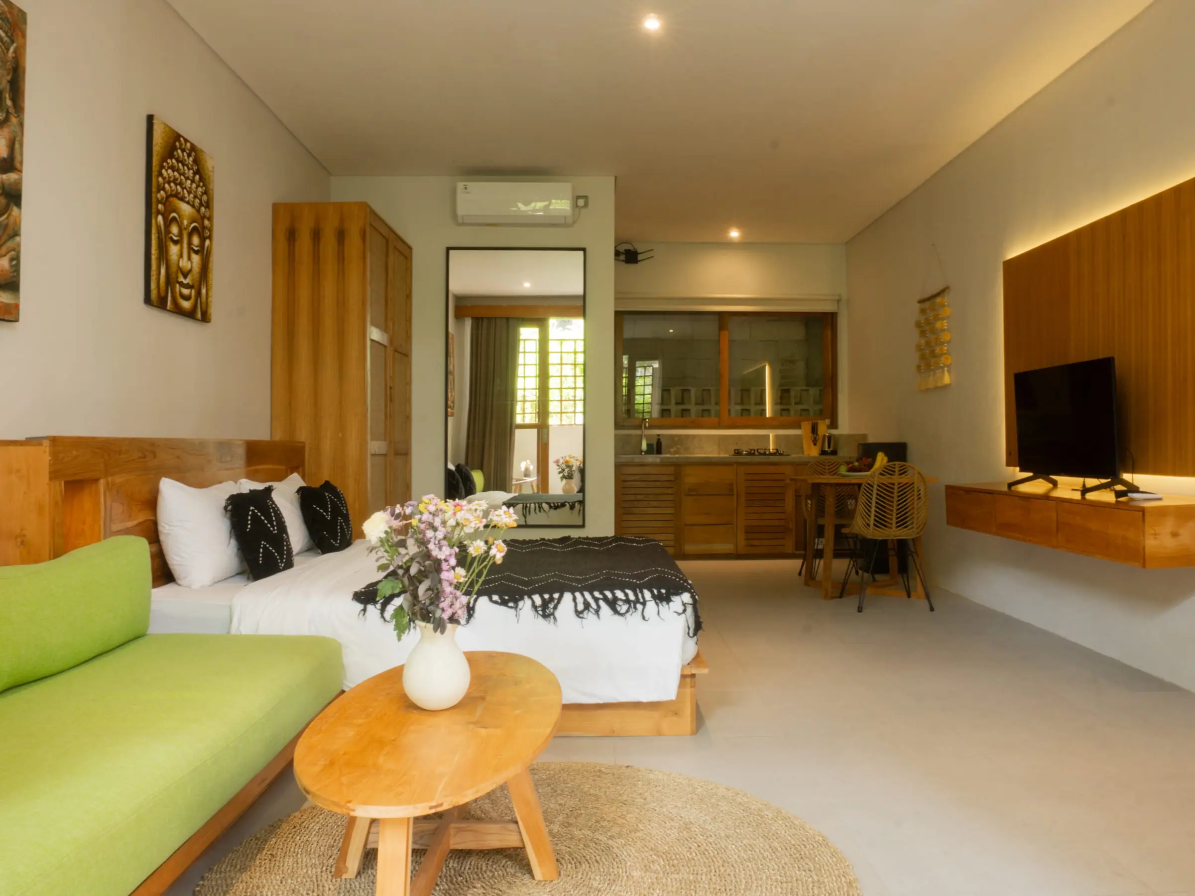 Bright villa room with green sofa, bed and wooden table