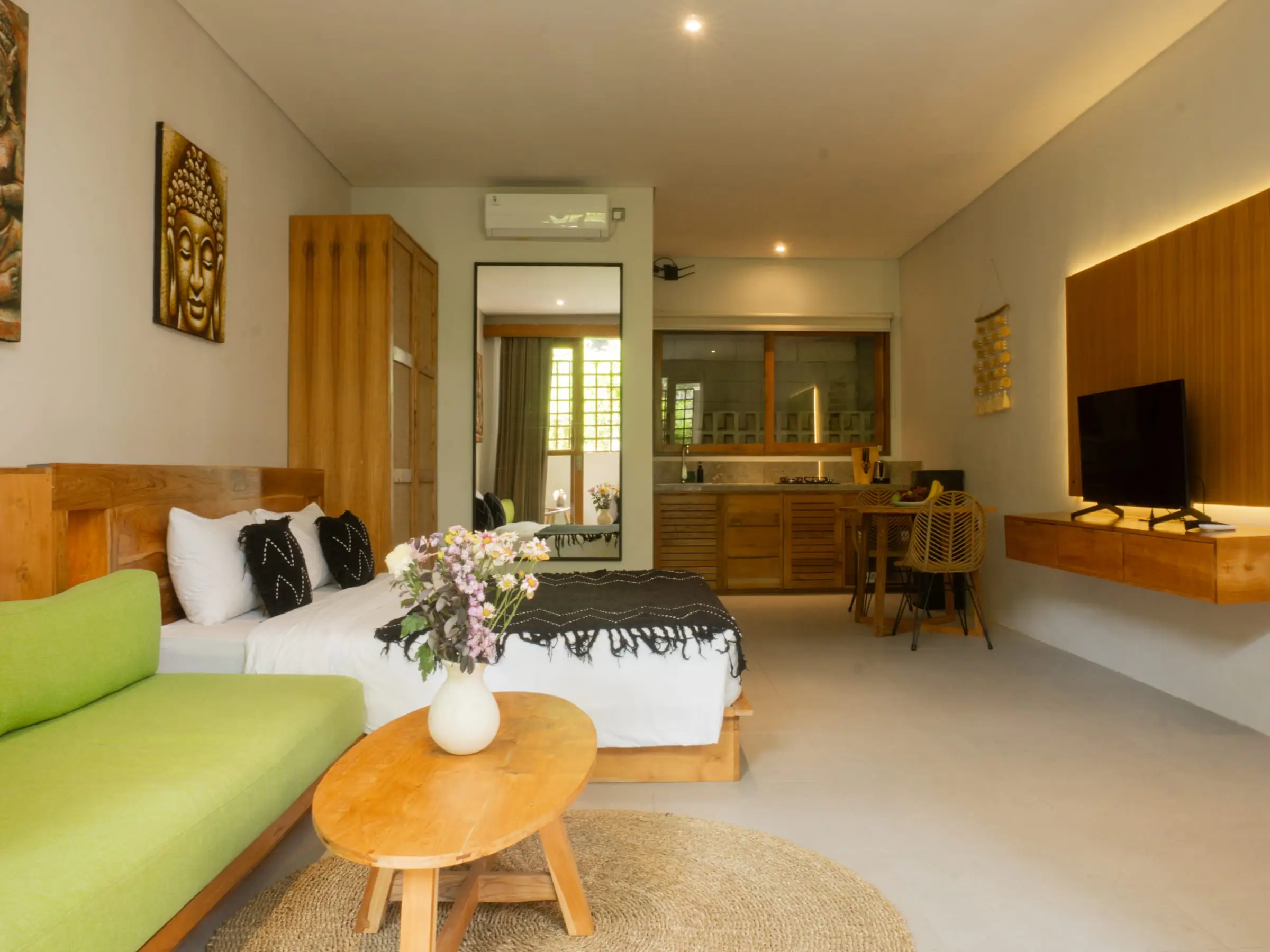 Bright villa room with green sofa, bed and wooden table